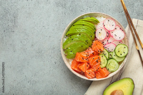 Obraz Poke bowl, a traditional hawaiian dish with diced raw salmon, avocado, vegetables served with rice and vegetables, a healthy meal, copy space