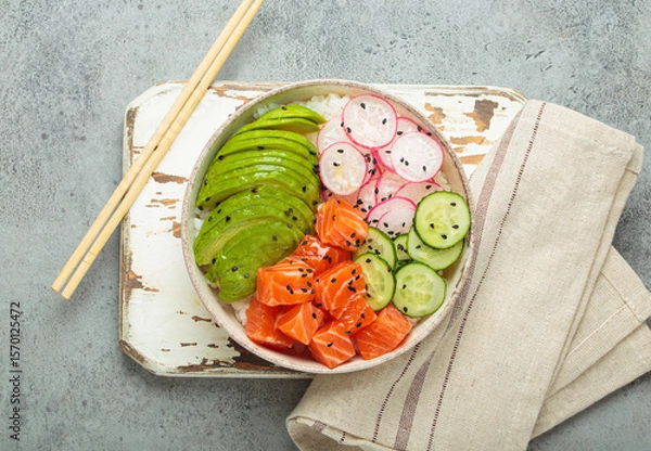 Obraz Poke bowl, a traditional hawaiian dish with diced raw salmon, avocado, vegetables served with rice and vegetables, a healthy meal