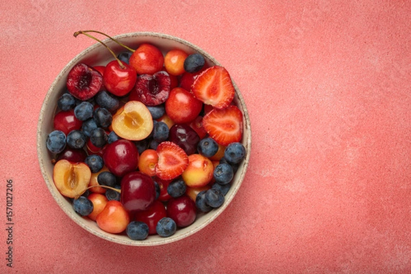Obraz Simple, healthy, and delicious mix of fresh summer fruits is presented in a bowl, sitting on a textured pink background top view