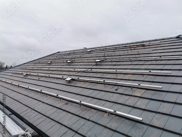 Fototapeta The structure on the house's roofing felt for installing solar panels, with microinverters also installed