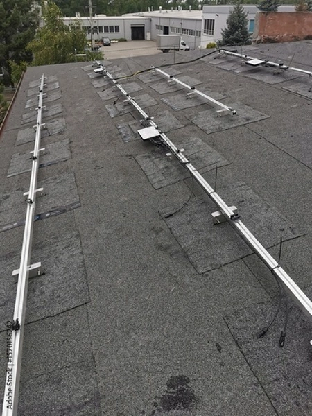 Fototapeta The structure on the house's roofing felt for installing solar panels, with microinverters also installed
