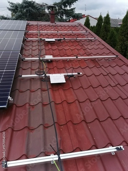 Fototapeta The structure on the house's roofing felt for installing solar panels, with microinverters also installed
