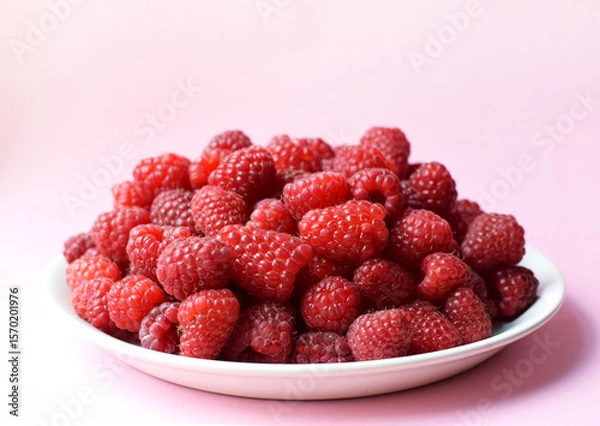 Fototapeta Ripe red raspberries on a white plate. Sweet raspberry background. Berries close-up. Healthy food