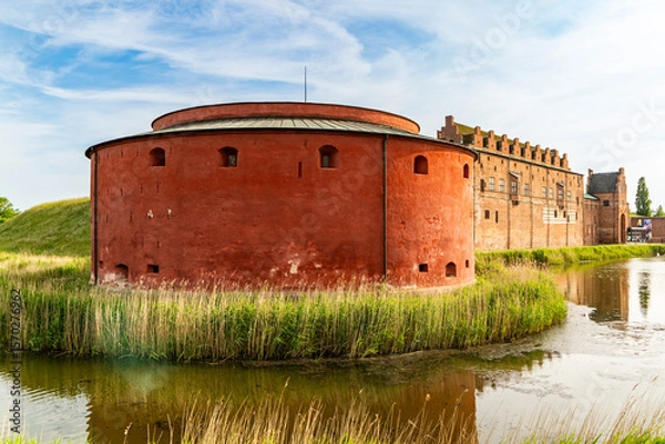 Fototapeta Impressive round tower of historic Malmohus Castle surrounded by water