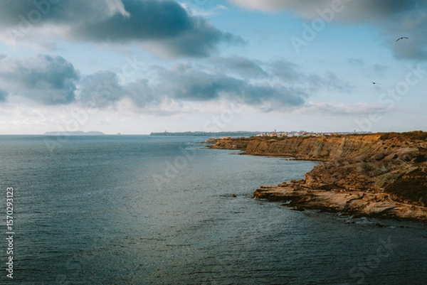 Obraz The rocky coastline stretches into the distance, meeting the vast expanse of the Atlantic Ocean under a dramatic, cloud filled sky, offering a breathtaking view of the Portuguese coast