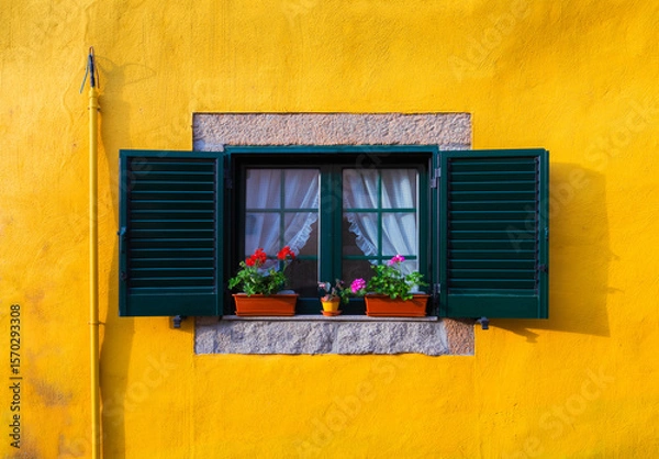 Obraz Green shutters framing a window with flower pots and sheer curtains. Set against a vibrant yellow wall. Create a picturesque scene in Tarouca. Portugal. Showcasing traditional Portuguese architecture
