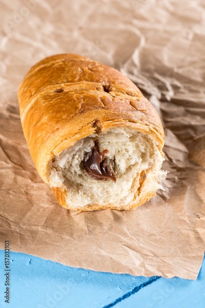 Obraz Sliced chocolate croissant on the wrinkled brown paper