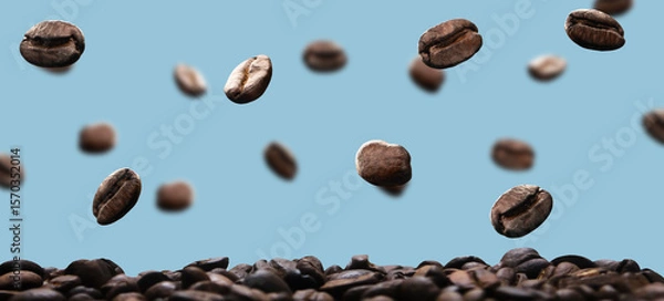 Fototapeta roasted coffee beans falling and floating in the air with a blue background