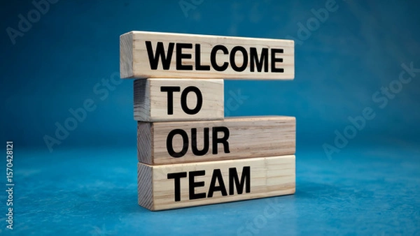 Obraz Wooden blocks stacked to spell out welcome to our team against a vibrant blue background symbolizing new beginnings and team integration