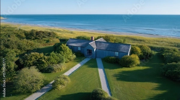 Obraz Top-down drone capture of Cape Cod cottage with symmetrical lawn path late afternoon shadows stretch horizon sand tones