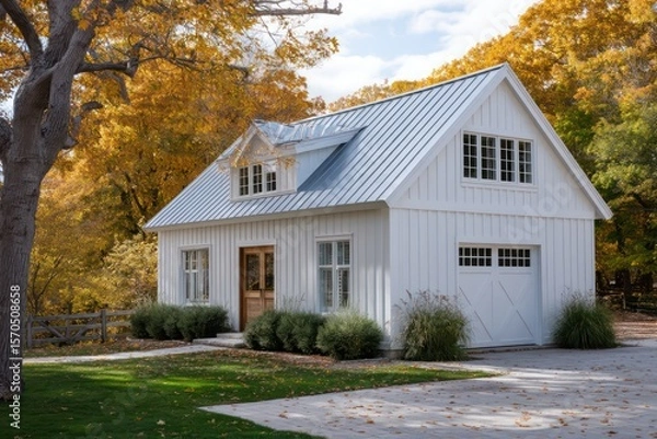 Obraz White barn-inspired house framed by autumn trees cool sidelight with soft bloom deep ambient shadows across clapboard siding