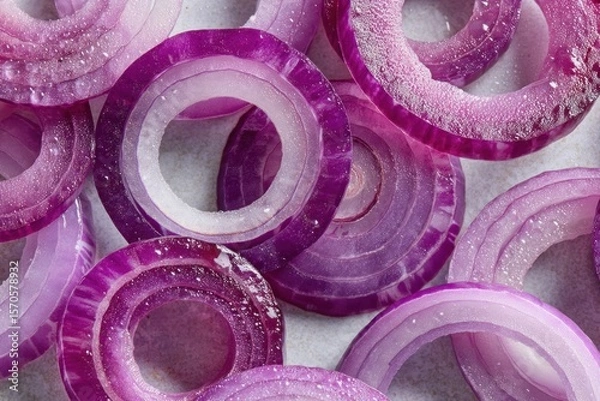 Fototapeta Freshly sliced red onions display a rich palette of purples and whites, highlighting their crisp texture and juicy appeal