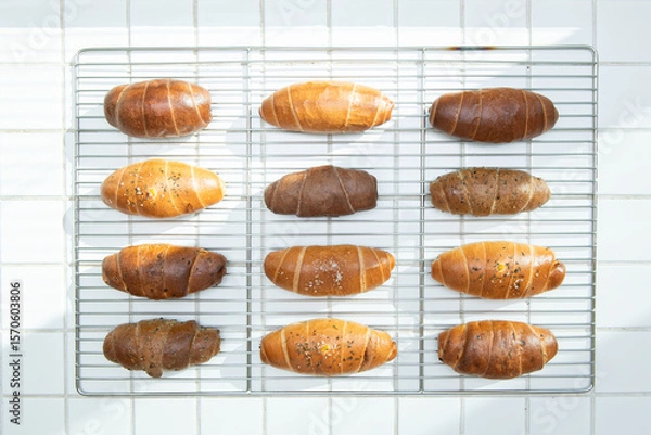 Fototapeta Assortment of Freshly Baked Bread Rolls on a Cooling Rack