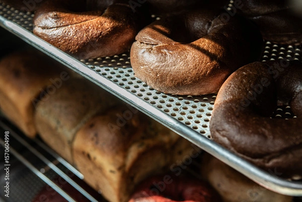 Fototapeta Freshly baked buns on a metal rack in a bakery.