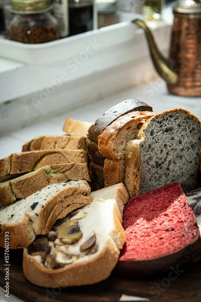 Fototapeta Variety of bread on wooden cutting board in a bakery shop.