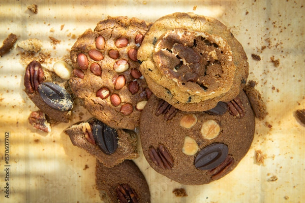 Fototapeta Oatmeal cookies with pecan nuts and raisins on wooden background