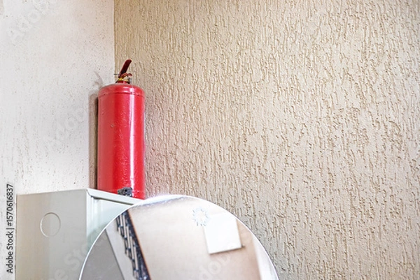Obraz fire extinguisher in the corner of the classroom wall. safety and rules