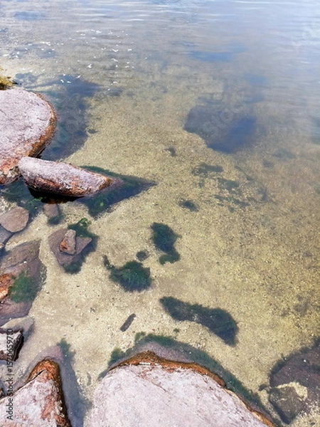 Fototapeta Amazing colorful background of the water surface of the Dnieper disturbed by a light wind over a stone bottom that shines through the water column.