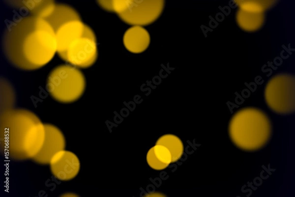 Fototapeta Glowing yellow soft bokeh lights on dark background for abstract elegant party ambiance romantic decoration or vintage style visuals