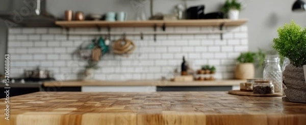Fototapeta The wooden countertop in a modern kitchen with decorative elements and greenery.