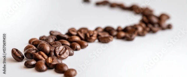 Fototapeta The coffee beans scattered in a creative and artistic arrangement on a white surface.