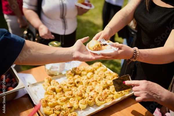 Obraz Hands of people taking food from a plastic plate during a banquet