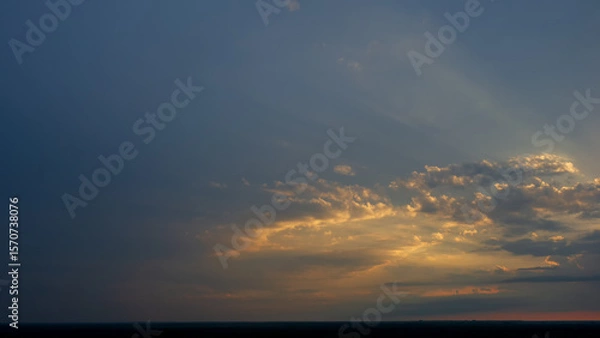 Fototapeta Evening clouds in the sky on the horizon line at sunset.