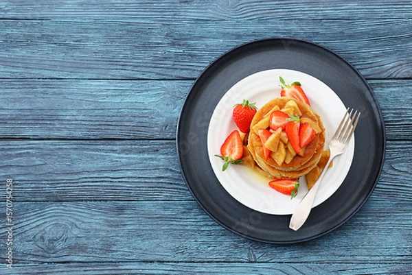 Fototapeta pancakes topped with apple slices and strawberries