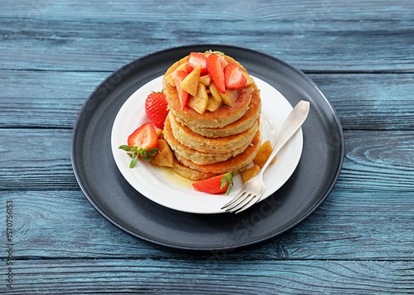 Fototapeta pancakes topped with apple slices and strawberries