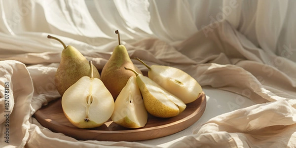 Fototapeta Ripe pears on wooden plate with soft fabric backdrop
