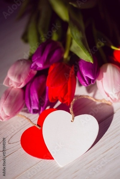 Obraz Colorful tulip bouquet is being shown in flat design on pale wooden surface with heart tags