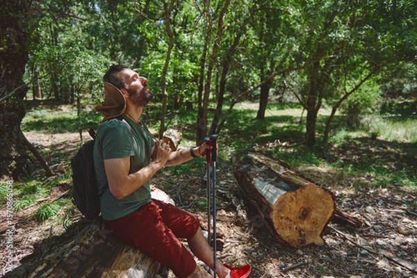 Fototapeta Man Enjoying a Peaceful Hiking Break in a Tranquil Forest Setting