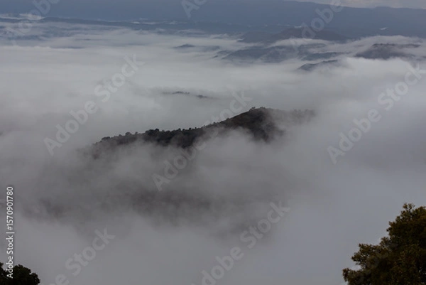 Fototapeta Mountain peak emerging from the fog that covers it