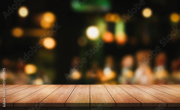 Fototapeta Empty wooden table top with lights bokeh on blur restaurant background.