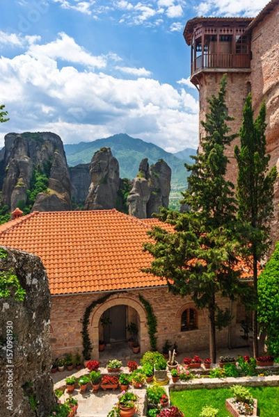 Fototapeta Historic monastery courtyard with flowers and mountain view in Meteora Greece