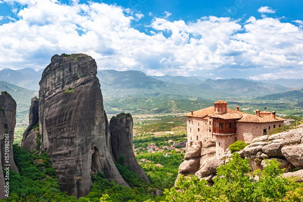 Fototapeta Ancient Meteora monastery perched on cliff edge beside massive rock formation in Greece