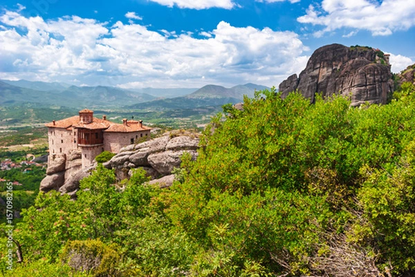 Fototapeta Ancient Meteora monastery perched on cliff edge beside massive rock formation in Greece