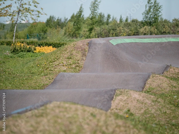 Obraz Pump track close up. Pumptrack curves with lines. Asphalted bicycle race track, pump track outdoors, kids playground. Racing speed track
