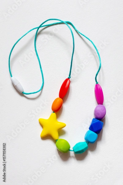 Obraz Colorful silicone baby teether necklace featuring various shapes and a star design, intended for soothing teething infants. Bright and engaging, suitable for babies' sensory needs.