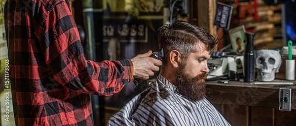 Fototapeta Man client getting haircut. Hipster barbershop. Hands of barber with hair clipper. Barber with clipper trimming hair