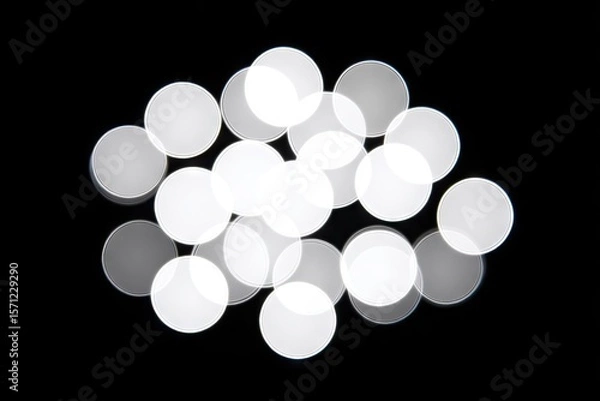 Fototapeta Abstract cluster of blurred, white circles on a black background