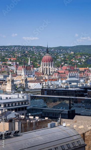 Fototapeta Panoramic view of Budapest with the iconic Hungarian Parliament and Buda Hills, captured from the observation deck of St. Stephen’s Basilica on a clear summer day.