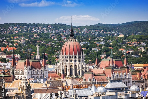 Fototapeta Panoramic view of Budapest with the iconic Hungarian Parliament and Buda Hills, captured from the observation deck of St. Stephen’s Basilica on a clear summer day.