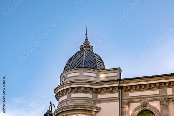 Fototapeta A golden-hour close-up of a historical dome. Shadows play across the detailed cornices and curved architecture. Use  for luxury real estate and architectural firm branding.