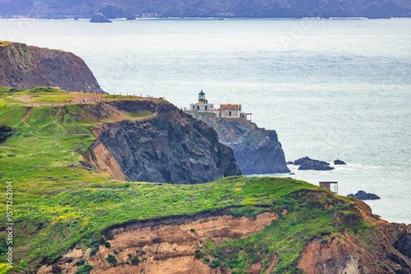 Fototapeta Scenic view of Point Bonita Lighthouse perched on a dramatic cliff along the Marin Headlands, overlooking the Pacific Ocean under soft coastal light