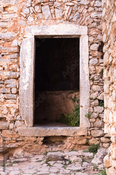 Fototapeta Stone wall with portal of a medieval fortress.
