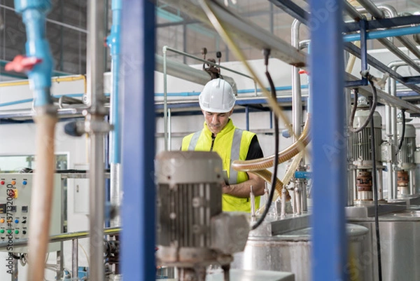 Fototapeta Engineers or factory managers wearing safety helmet inspect the machines in the production line. Utility inspector check machine and test the system to meet the standard. machine, maintenance.