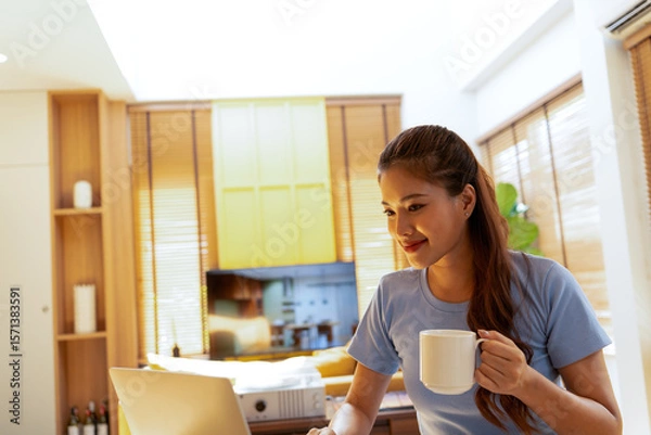 Fototapeta Woman enjoys book and music in modern abode.