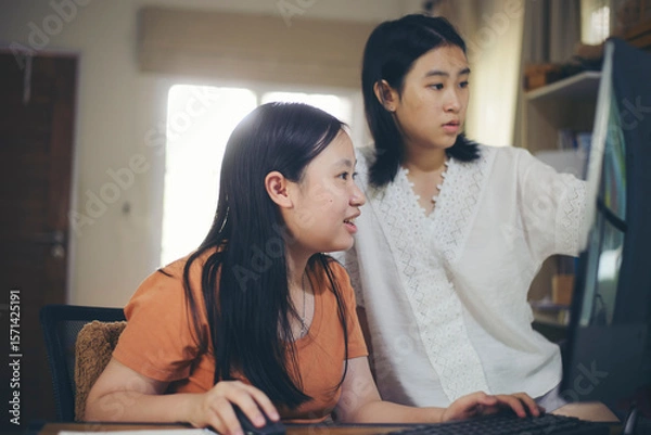 Fototapeta Asian children using digital tablet with stylus pen write and do homework at home. Stress Thai Student working online to study for the exam. Education and E-learning concept.