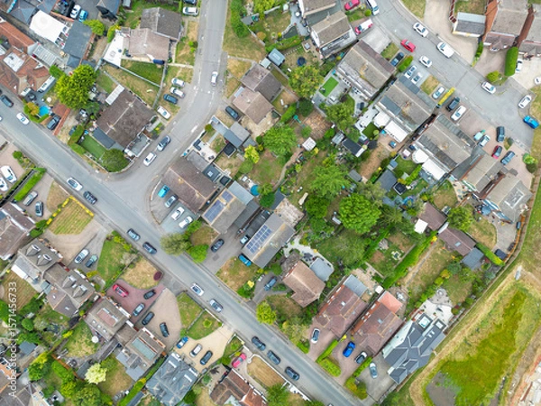 Fototapeta Drone view of a typical British suburban street showing both terraced and detached houses, some with large extensions and fitted solar panels to the roofs.